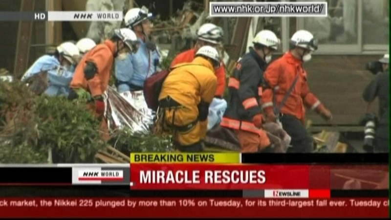Záchranári nesú muža, ktorý prežil, Japonsko